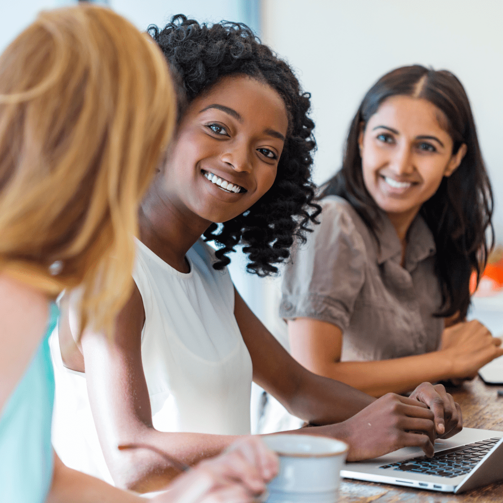 Three women working together on a computer